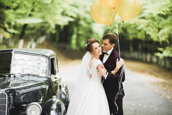 Glückliches Brautpaar, Mann und Frau küssen sich in der Nähe von stylischem Retro-Auto — Stockfoto