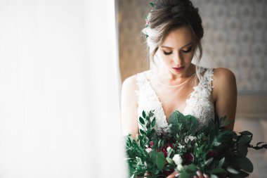 Tüylü, lüks makyaj, saç stili, stüdyo içi fotoğraf çekimi olan güzel bir gelin.