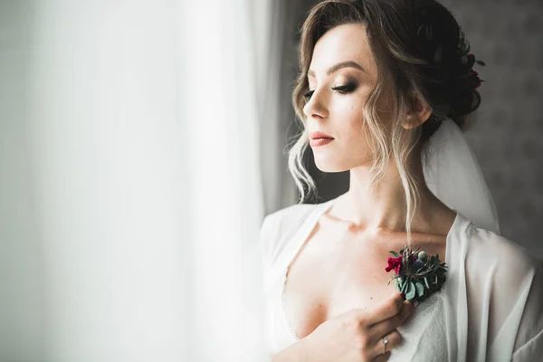 Hermosa novia con vestido de novia de moda con plumas con maquillaje de lujo deleite y peinado, estudio sesión de fotos interior —  Fotos de Stock