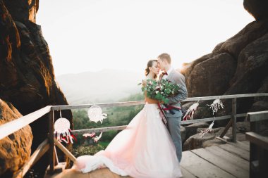 Düğün gününde damadın ve gelinin dağların eteklerinde mutlu mesut evlenecekler. Doğada mutlu evlilikler, yumuşak güneşli ışıklar.