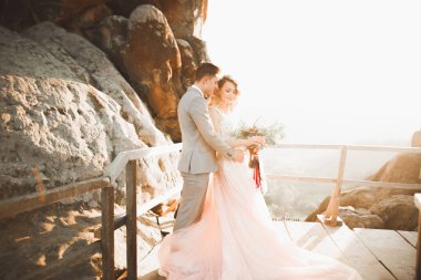 Düğün gününde damadın ve gelinin dağların eteklerinde mutlu mesut evlenecekler. Doğada mutlu evlilikler, yumuşak güneşli ışıklar.