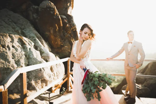 Beautifull wedding couple kissing and embracing near mountain with perfect view — Stock Photo, Image