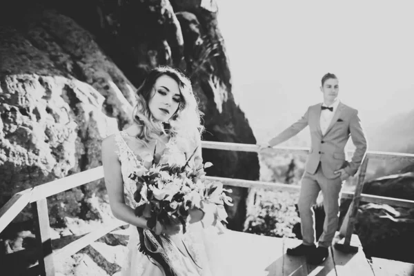 Glücklich schönes Hochzeitspaar Braut und Bräutigam am Hochzeitstag im Freien auf dem Bergfelsen. Glückliches Ehepaar im Freien in der Natur, weiches Sonnenlicht — Stockfoto