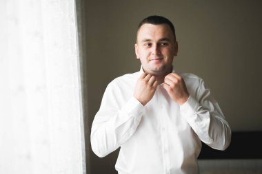 Güzel adam, damat poz veriyor ve düğüne hazırlanıyor.