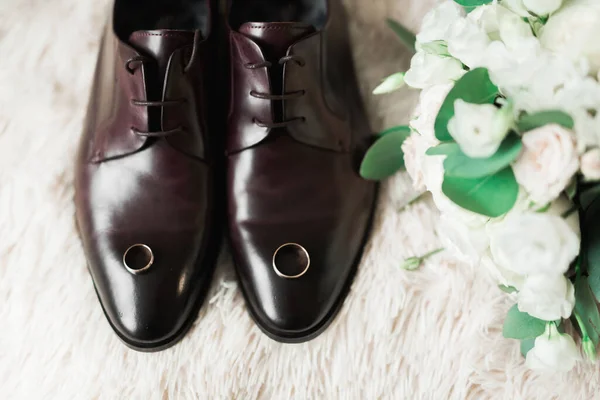 Conjunto de zapatos de moda de hombre con dos anillos de boda dorados y hermoso ramo de bodas con diferentes flores, rosas — Foto de Stock