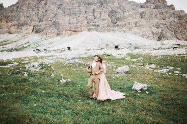 Dağlarda güzel genç bir çift. Aşıkların kış yürüyüşü. Erkek kadına sarılıyor.