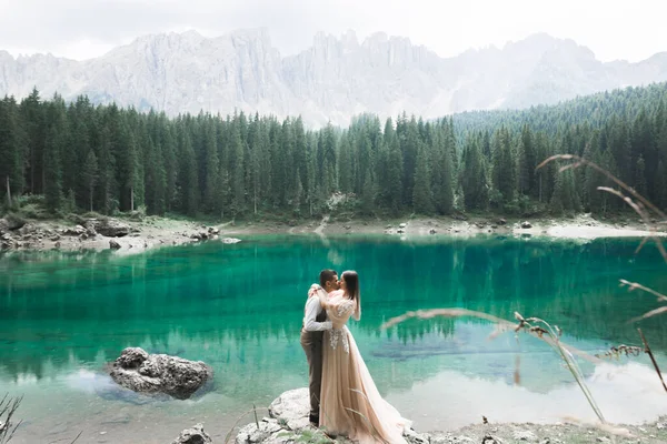 Piękna nowoczesna para całuje się w pobliżu jeziora w górach — Zdjęcie stockowe