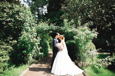 Romantik düğün anı, yeni evli çiftin gülümseyen portresi, gelin ve damadın kucaklaşması