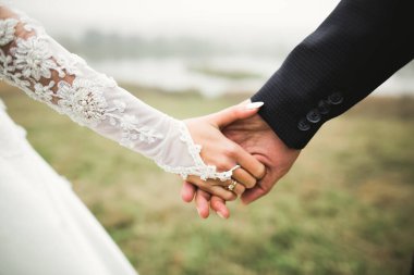 Düğün günü el ele tutuşan çift, damat ve gelin.