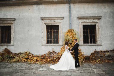 Göz kamaştırıcı mutlu çift birbirine yakın duruyor ve gözlerinin içine bakıyor.