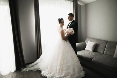 Doğadaki düğün çifti birbirine sarılıyor. Beyaz elbiseli güzel bir kız. Takım elbiseli adam