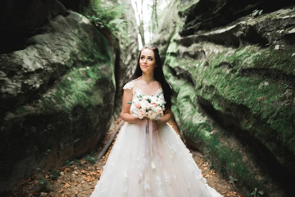 Ritratto di splendida sposa con capelli lunghi in posa con grande bouquet — Foto Stock