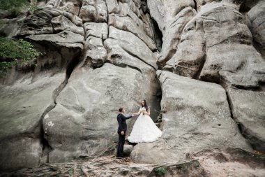 Harika bir gelin damada poz veriyor ve harika manzaralı dağlarda eğleniyor. Mesajlaşacak yer, düğün çifti.