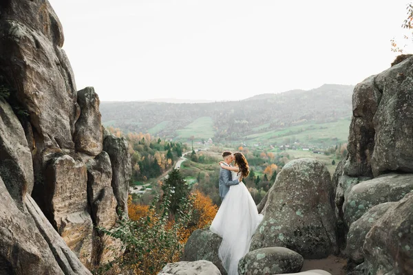 Dağların arka planında sevgi dolu bir koca ve kadın. Sevgili çift duygusal olarak vakit geçirir. — Stok fotoğraf