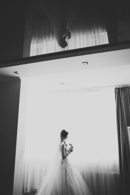 Beyaz elbiseli lüks gelin düğün törenine hazırlanırken poz veriyor.