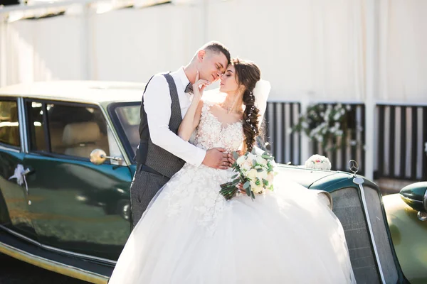 Wedding bride and groom, elegant couple staying near retro wedding car — Stock Photo, Image