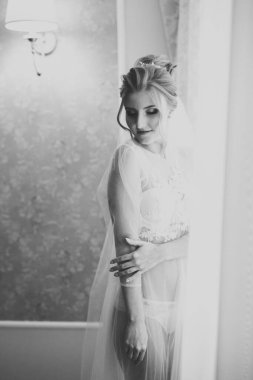 Beyaz elbiseli lüks gelin düğün törenine hazırlanırken poz veriyor.