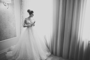 Beyaz elbiseli lüks gelin düğün törenine hazırlanırken poz veriyor.