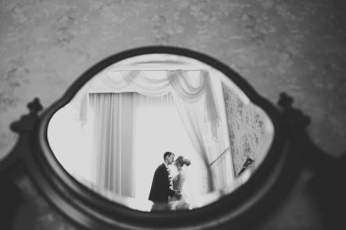 Güzel gelin ve damat düğün günlerinde kucaklaşıp öpüşürler.