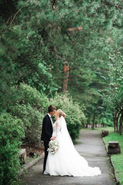 Güzel gelin ve damat düğün günlerinde kucaklaşıp öpüşürler.