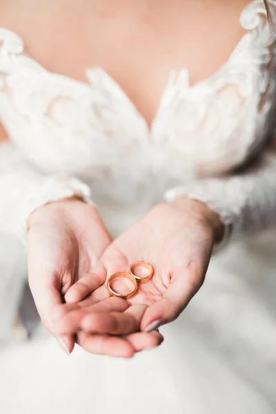 Vacker lyx brud i elegant vit klänning håller vigselringar i händerna — Stockfoto