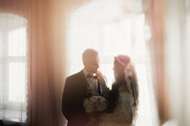 Göz kamaştırıcı mutlu çift birbirine yakın duruyor ve gözlerinin içine bakıyor.