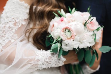 Güzel, genç bir çift ellerinde çiçeklerle poz veriyorlar.