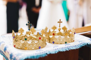 Kilisedeki masanın üzerinde altın taçlar var.