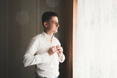 Güzel adam, damat poz veriyor ve düğüne hazırlanıyor.