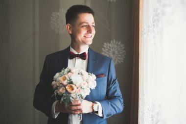 Güzel adam, damat poz veriyor ve düğüne hazırlanıyor.