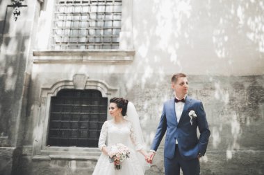 Güzel, mutlu bir düğün çifti, güzel şehirde uzun beyaz elbiseli bir gelin.