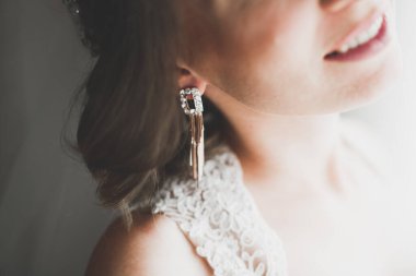 Cüppeli muhteşem gelin bir odada düğün töreni için poz veriyor ve hazırlanıyor.