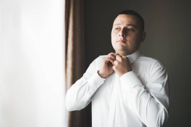 Güzel adam, damat poz veriyor ve düğüne hazırlanıyor.