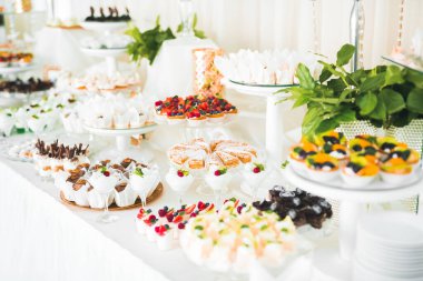 Çeşitli lezzetli tatlılar, yemek fikirleri ve kutlamalarla dolu bir büfe.