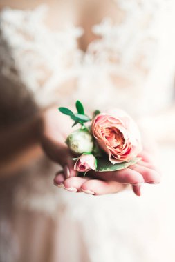 Gelin çiçekli büyük ve güzel bir düğün buketi tutuyor.