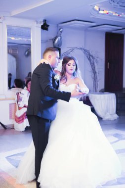 Güzel beyaz bir çift yeni evlendiler ve ilk danslarını ediyorlar.