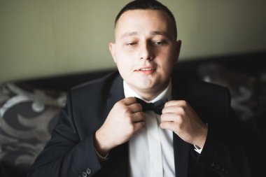 Güzel adam, damat poz veriyor ve düğüne hazırlanıyor.