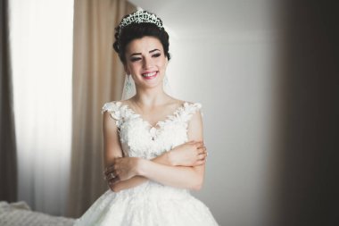 Beyaz elbiseli lüks gelin düğün törenine hazırlanırken poz veriyor.