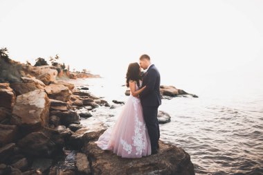 Güzel bir sahilde poz veren genç bir çiftin mutlu ve romantik sahnesi.