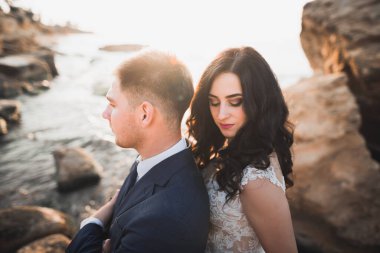 Güzel bir sahilde poz veren genç bir çiftin mutlu ve romantik sahnesi.