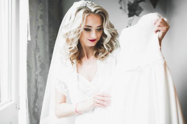 Beyaz elbiseli lüks gelin düğün törenine hazırlanırken poz veriyor.