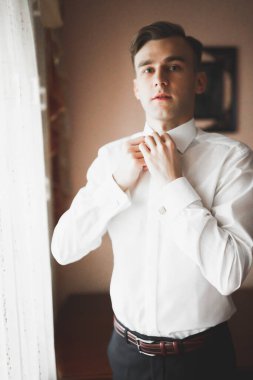 Güzel adam, damat poz veriyor ve düğüne hazırlanıyor.