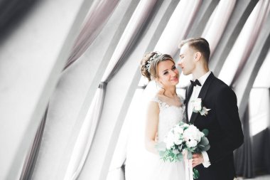 Mükemmel bir çift gelin ve damat düğün günlerinde poz verip öpüşürler.