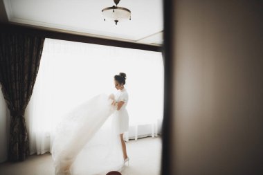 Beyaz elbiseli lüks gelin düğün törenine hazırlanırken poz veriyor.