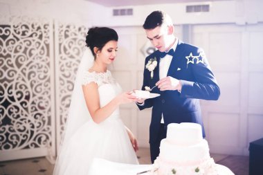 Gelin ve damat düğün pastasını kesiyor.