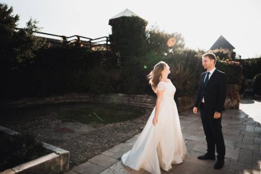 Yeni evli çift el ele tutuşurken parkta koşup zıplıyorlar.