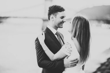 Düğün çifti, damat ve gelin kucaklaşıyor, nehir kenarında.