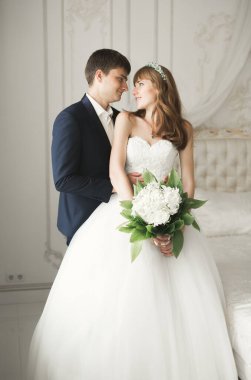 Çiçek buketi taşıyan mükemmel bir düğün çifti.