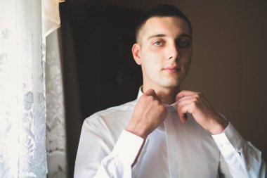 Güzel adam, damat poz veriyor ve düğüne hazırlanıyor.