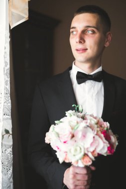 Güzel adam, damat poz veriyor ve düğüne hazırlanıyor.